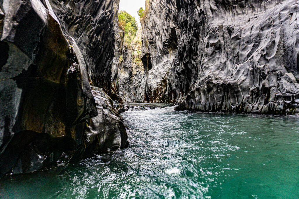 Alcantara river gorge flowing among basalt geological formations. Gole Alcantara Botanical and Geological Park in Sicily near to Etna volcano in Italy